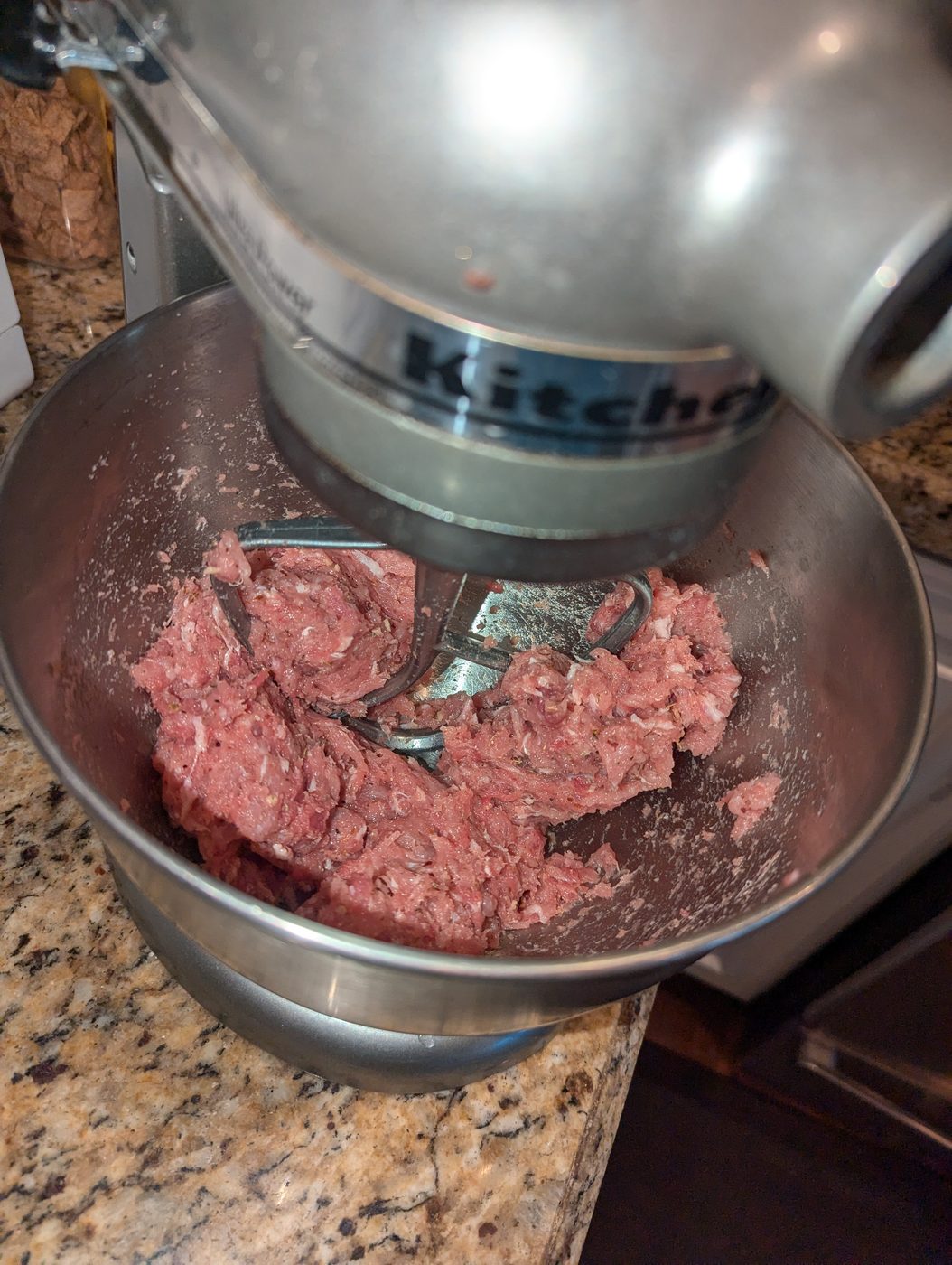 Seasoned pork sausage mixed with fennel and herbs in a stand mixer bowl