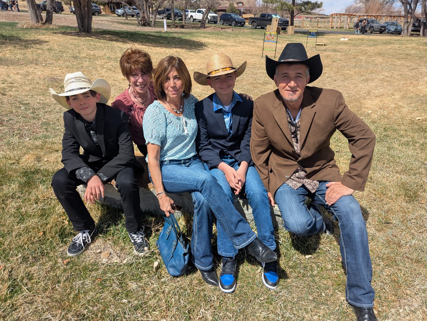 Family portrait outdoors, some in cowboy hats