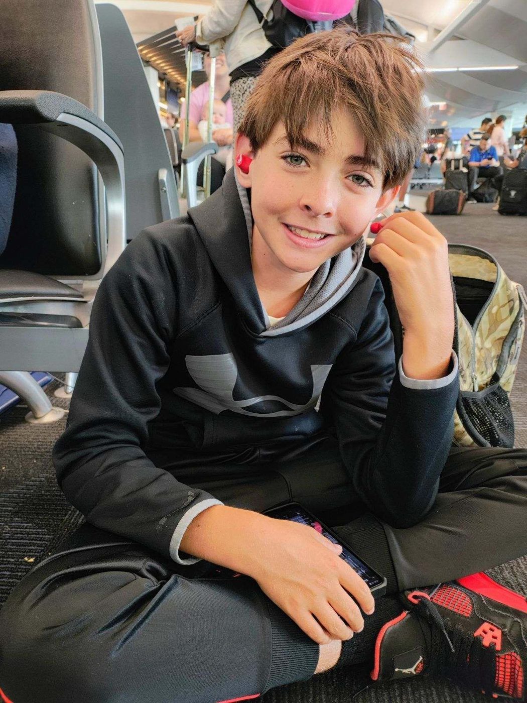 Son sitting at an airport terminal